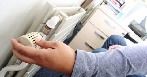 Main réglant la température d’un radiateur